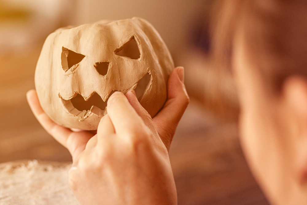 artist sculpting pumpkin from clay